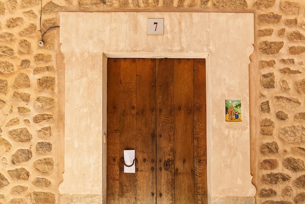 Photo porte en bois numéro sept dans le mur de pierre. porte en bois.
