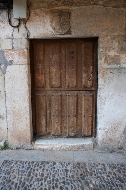 Photo porte en bois pour accéder à la maison, ancienne et en bois élaboré.