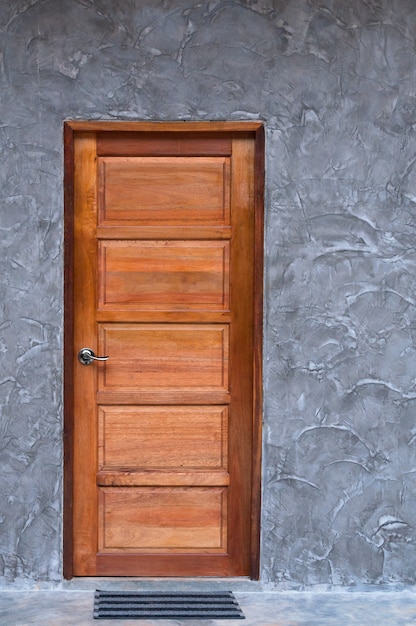 Porte en bois à la texture du mur en béton