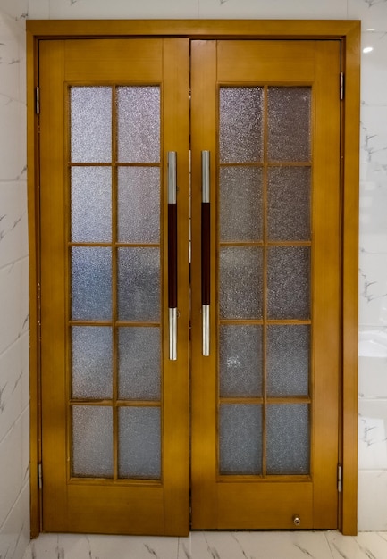 Porte en bois avec verre et poignée sur le mur