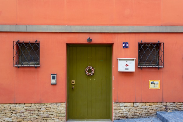 Photo porte en bois verte fermée sur fond de mur rouge