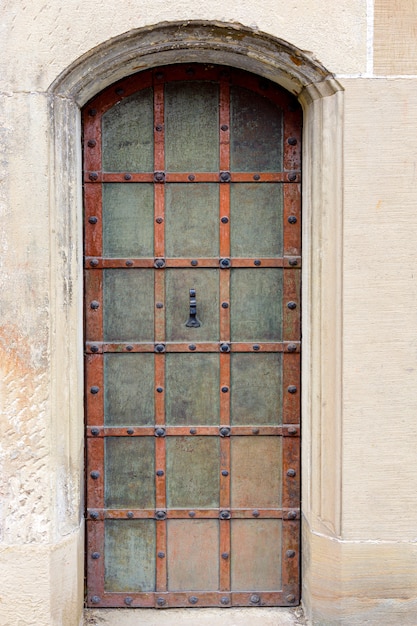 Photo porte cintrée antique avec des éléments décoratifs en fer