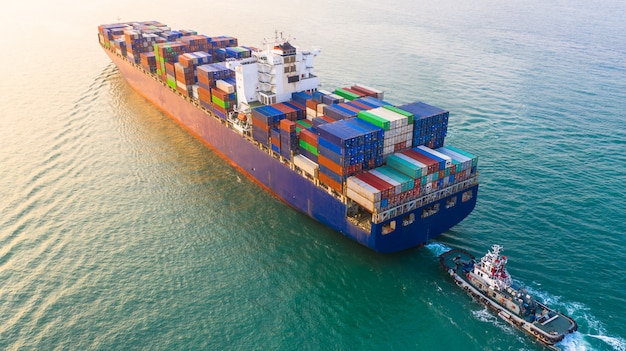 Porte-conteneurs arrivant dans le port, porte-conteneurs et remorqueur se rendant au port de mer, expédition et transport d’import-export logistique, vue aérienne.