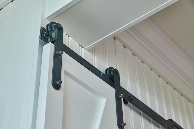 La porte coulissante noire moderne de la grange est un gros plan.