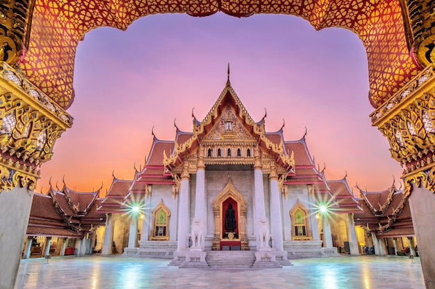 Photo porte dorée du temple bouddhiste wat benchamabophit de bangkok en marbre le lever du soleil du matin le ciel doré thaïlande