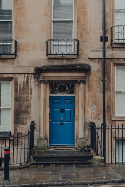 Photo la porte d'entrée bleu vif d'une maison traditionnelle en pierre calcaire à terrasses à bath, somerset, au royaume-uni