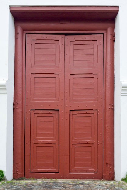 Porte d&#39;entrée rouge devant la maison d&#39;habitation