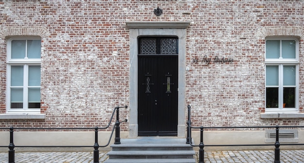 Une porte et une fenêtre d'époque sur la façade d'un vieux mur de pierre de cottage anglais.