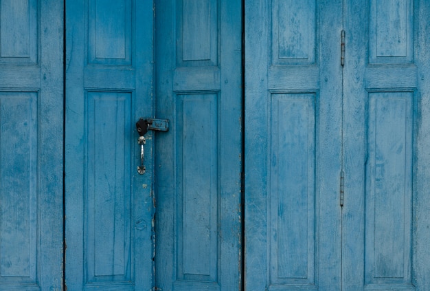 Porte fermée en bois bleu. Abstrait de la porte d'entrée Vintage. Maison ancienne abandonnée. Texture de porte en bois ancienne. Verrouillez la porte de l'ancienne maison.