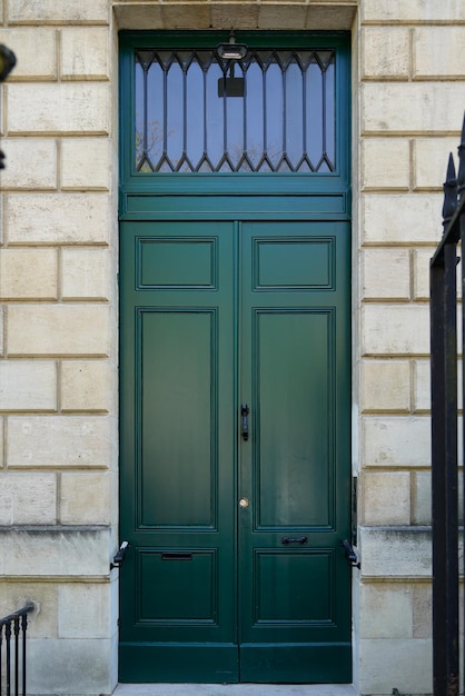 Porte haute en bois verte sur le mur français entrée ville rue façade en pierre classique