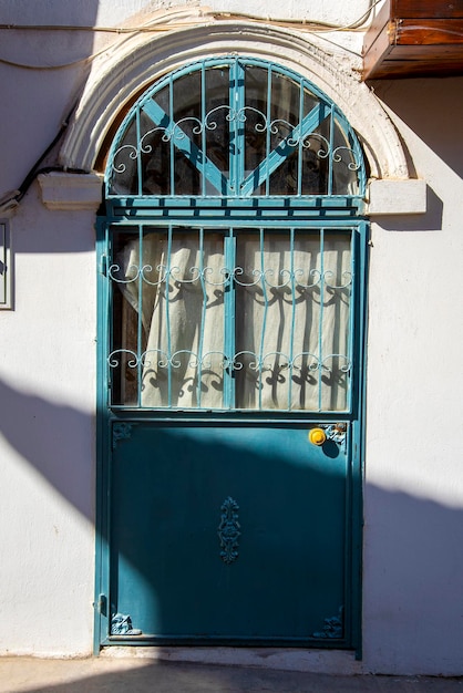 Une porte en métal de style turc vert avec un mur blanc