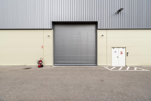 Photo porte métallique escamotable sur la façade d'un entrepôt industriel avec caméras de sécurité