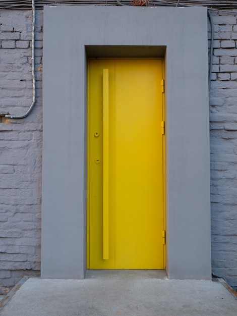 Porte métallique jaune vif dans un mur gris. entrée au café de la ville, restaurant