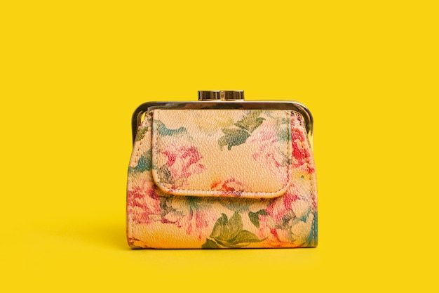 Un porte-monnaie floral sur fond jaune