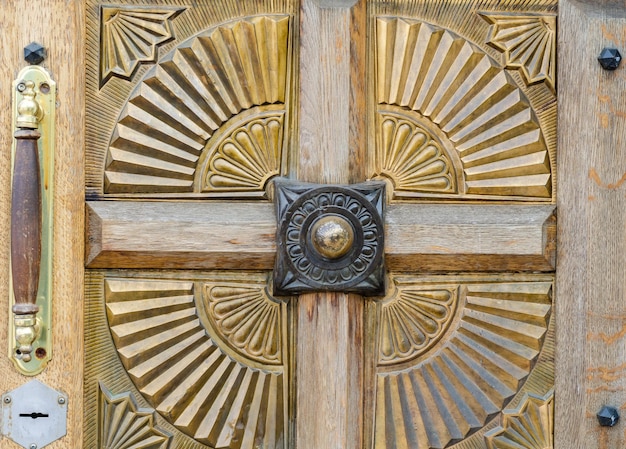 Une porte a une plaque en métal doré avec le mot "paix" dessus.