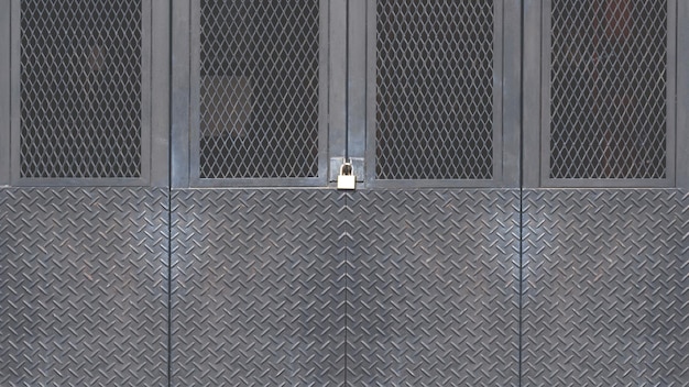 Photo porte pliante en métal noir fabriquée à partir de plaque diamant d'acier avec un treillis métallique de grille dans le style de loft industriel