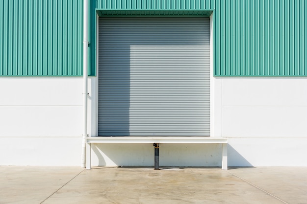 Photo porte à rideau et rampe de nivellement de quai à l'extérieur du bâtiment d'usine