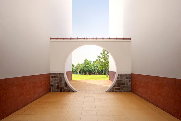 Porte ronde chinoise avec vue sur l'herbe verte et les arbres