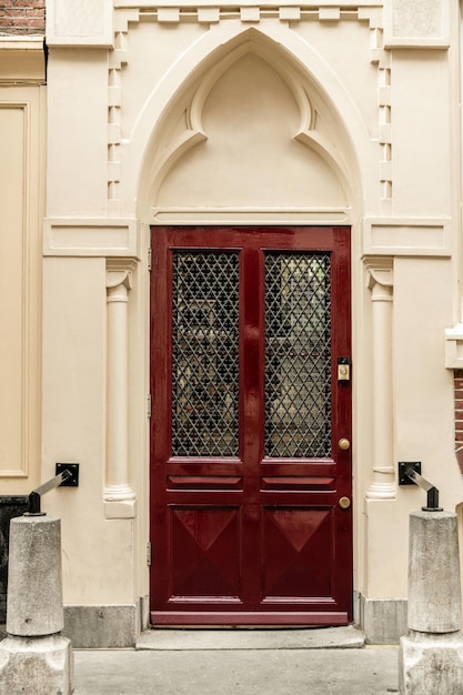 Une porte rouge d'un bâtiment avec un treillis