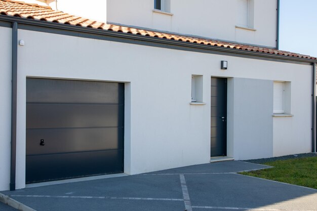 Porte sectionnelle gris façade d'entrée de garage gris maison moderne nouveau bâtiment maison en banlieue