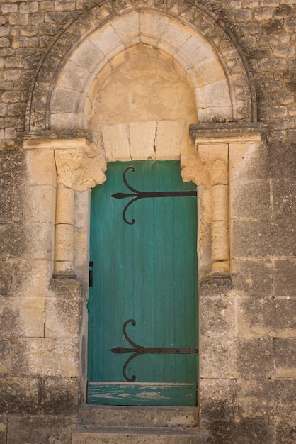 Porte verte en bois antique dans le mur en pierre de château