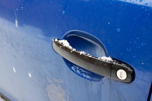 Porte de voiture bleue sur un fond de neige