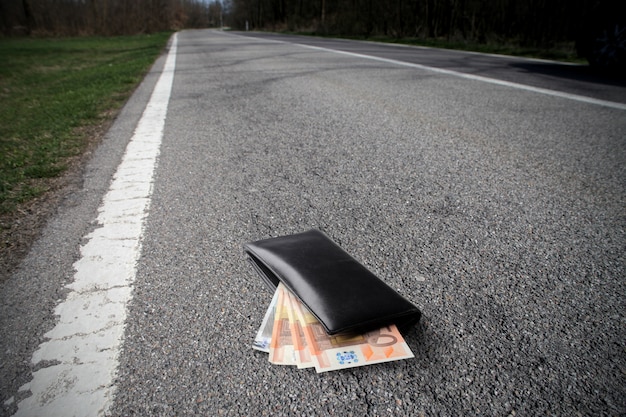 Portefeuille avec de l&#39;argent sur la route