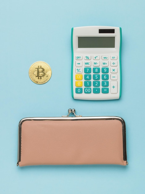 Portefeuille de calculatrice et Bitcoin sur fond bleu