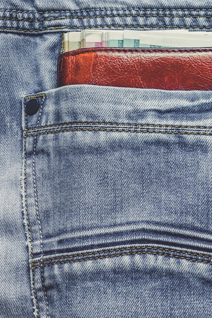 Portefeuille en cuir avec billets dans la poche de jeans