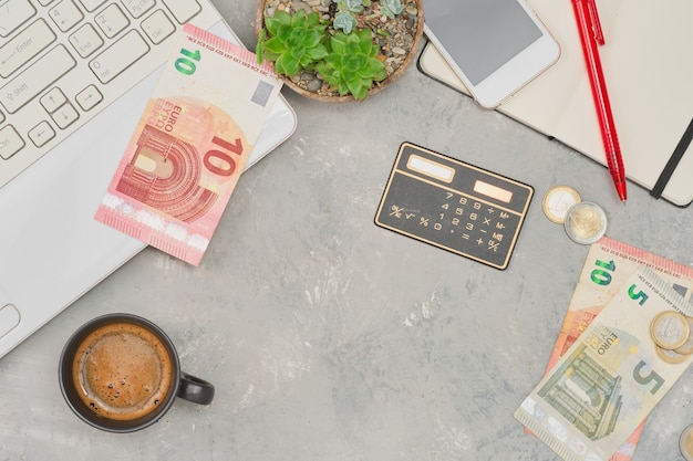 Portefeuille ouvert pour homme en cuir avec des pièces de monnaie en euros sur une table en bois blanc gros plan mise au point sélective faible profondeur de champ Planification des achats et dépenses ordinateur portable et bloc-notes à côté de la table