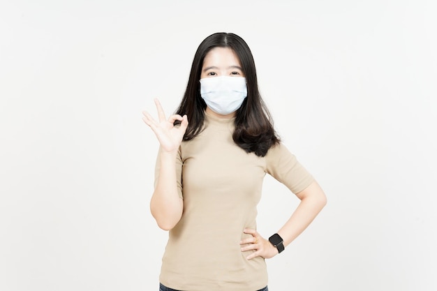 Porter un masque médical pour prévenir le virus Corona d'une belle femme asiatique isolée sur blanc