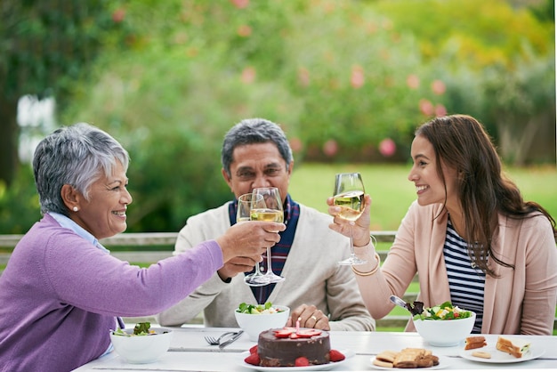 Porter un toast à l'homme de l'heure Photo recadrée d'une famille profitant d'un déjeuner d'anniversaire à l'extérieur