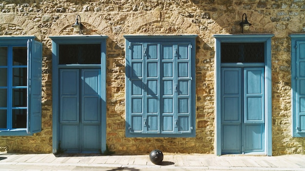 Portes et fenêtres en bois bleu volets sur murs en pierre jaune Grèce Nauplie