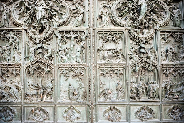 Portes forgées avec bas-reliefs en bronze sur la façade de la cathédrale Duomo di Milano. Italie