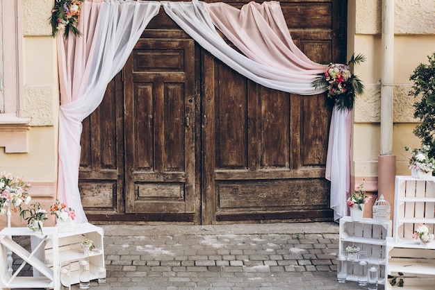 Portes de grange en bois de zone de photo de mariage rustique avec tissu et boîtes blanches avec des fleurs et des bougies à des arrangements de luxe shabby chic de photomaton de mariage élégant