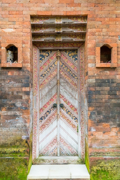 Photo portes sculptées en bois balinais avec ornements locaux traditionnels. traditions locales et concept d'artisanat