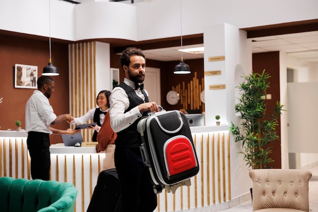 Photo un portier d'hôtel aide les touristes avec leurs sacs.