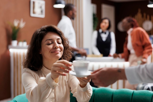 Photo portier d'hôtel servant une femme avec du café