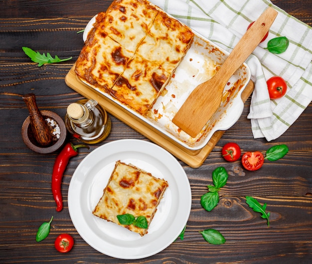 Portion de délicieuses lasagnes sur fond en bois