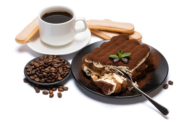 Portion de dessert tiramisu classique, biscuits savoiardi et tasse de café expresso frais isolé sur fond blanc