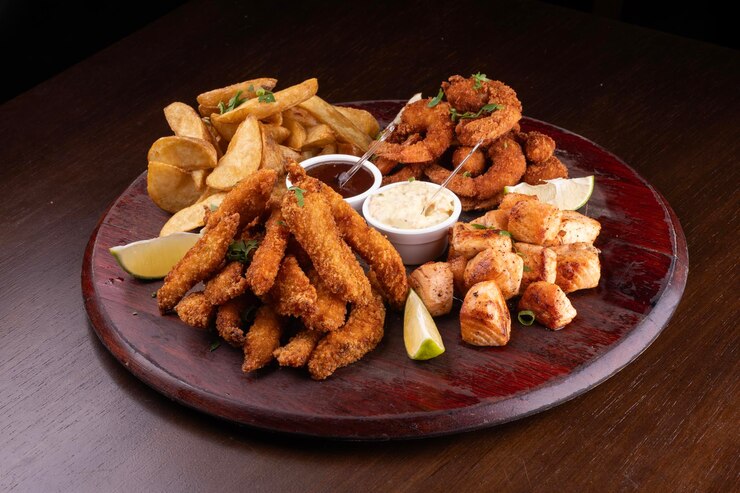 Photo portion de fruits de mer avec du poisson et des crevettes panés et du saumon grillé avec des frites