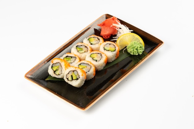 Photo une portion de maki sushi avec un assortiment de plats d'accompagnement japonais dans une assiette en céramique rectangulaire sur fond blanc