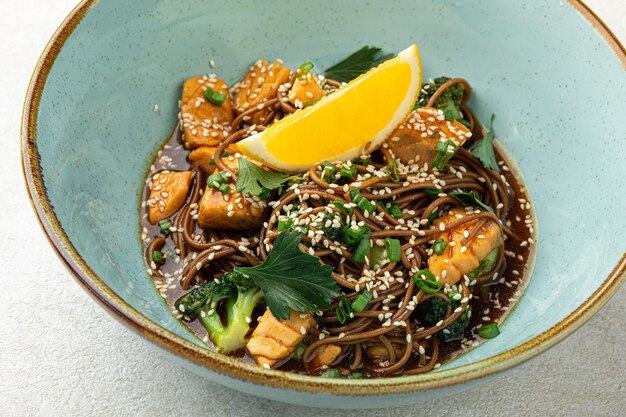 Une portion de nouilles de soba de saumon teriyaki avec des herbes