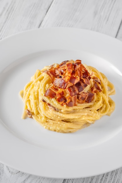 Portion de pâtes carbonara garnie de guanciale frite