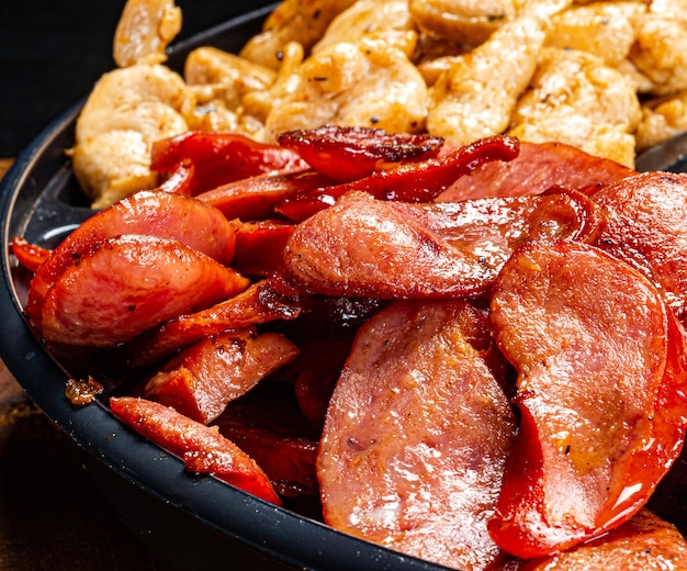 Portion de pepperoni et poulet frit sur une assiette rustique sur fond noirCuisine brésilienne typique