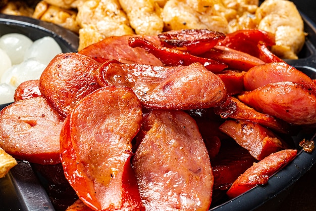 Portion de pepperoni et poulet frit sur une assiette rustique sur fond noirCuisine brésilienne typique