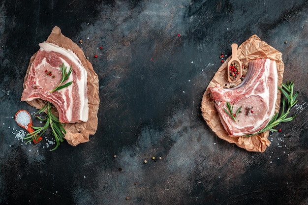 Portion de porc barbecue sur table sombre Côtelette de viande de porc sertie d'herbes et d'ingrédients bannière menu recette place pour texte vue de dessus