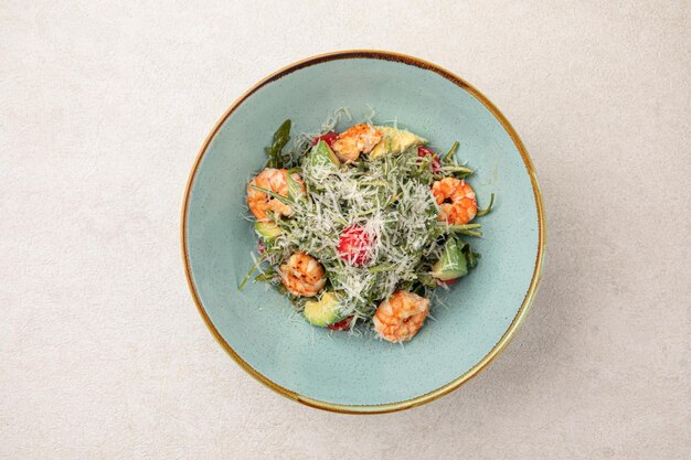 Une portion de salade César avec des crevettes.