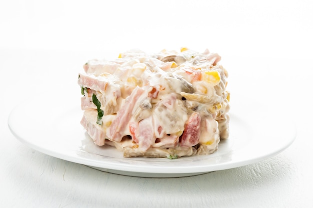 Portion de salade avec jambon, viande, champignons, légumes et mayonnaise