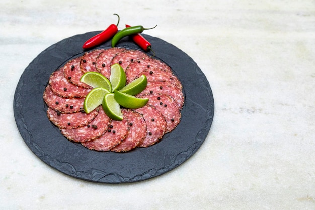 Portion de salami sur plaque de pierre noire